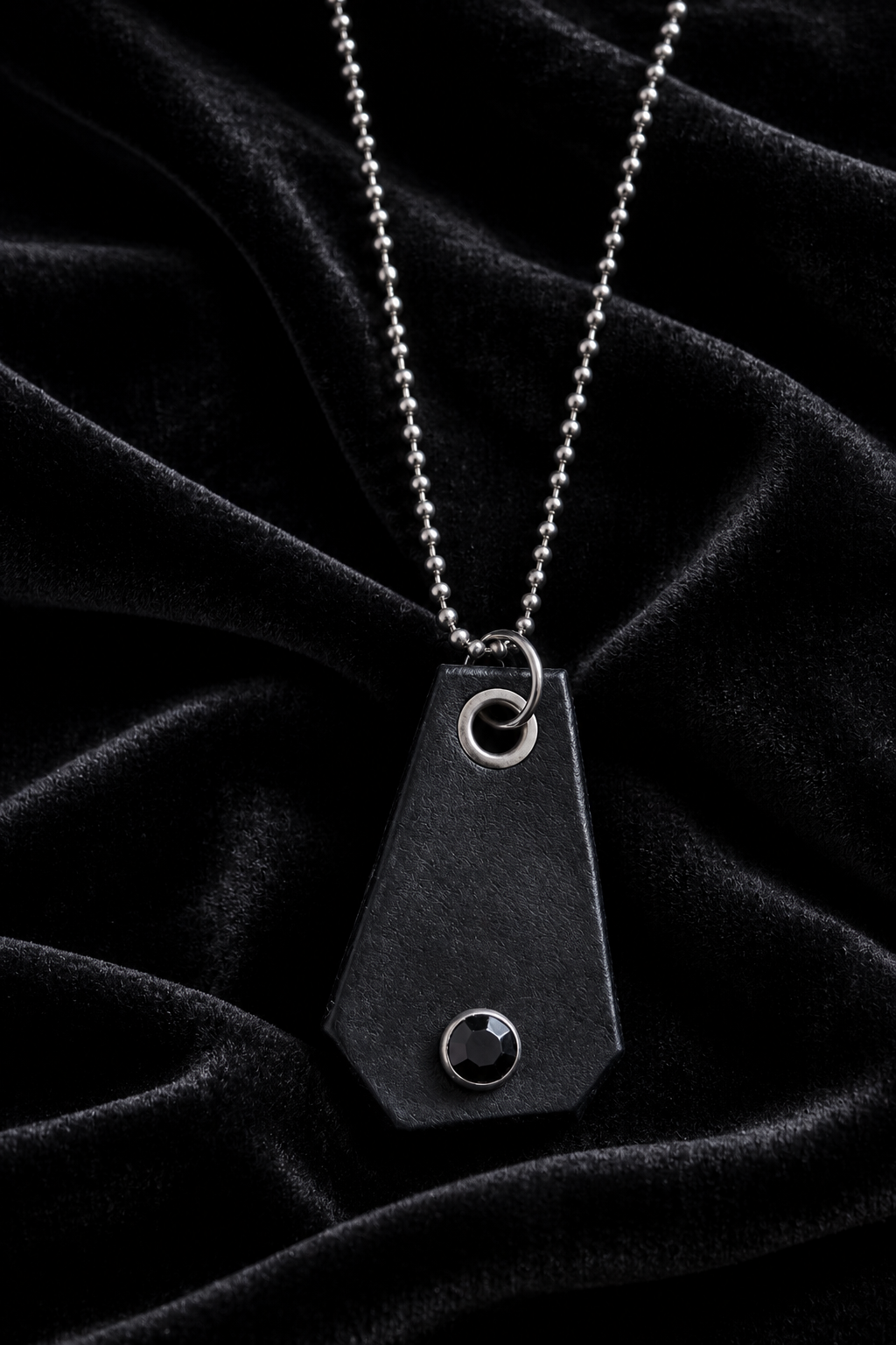 Black leather pendant necklace styled on black velvet
