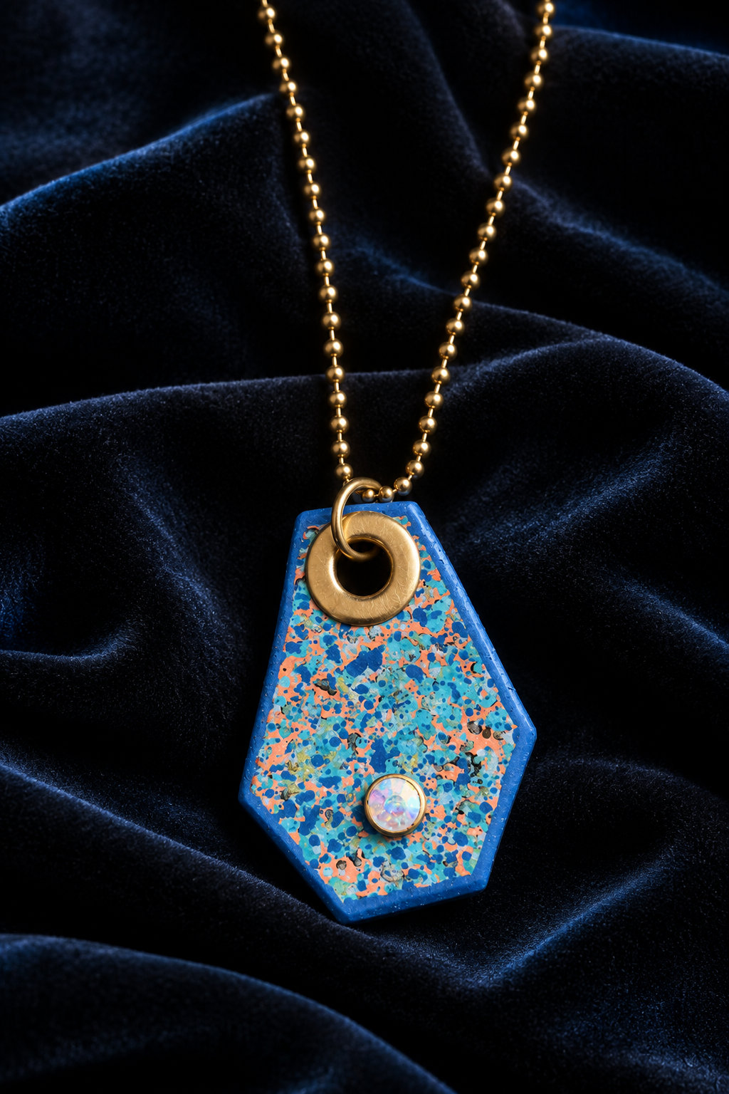 Blue pendant necklace styled on black velvet