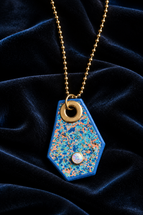 Blue pendant necklace styled on black velvet